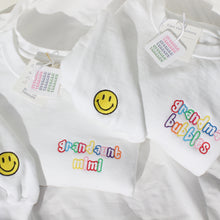 Load image into Gallery viewer, alternating rainbow threads in Skittles font. And a second location embroidery on cuff with a classic yellow fill smiley with black thread outline