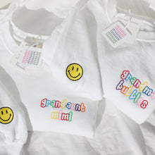 Load image into Gallery viewer, alternating rainbow threads in Skittles font. And a second location embroidery on cuff with a classic yellow fill smiley with black thread outline
